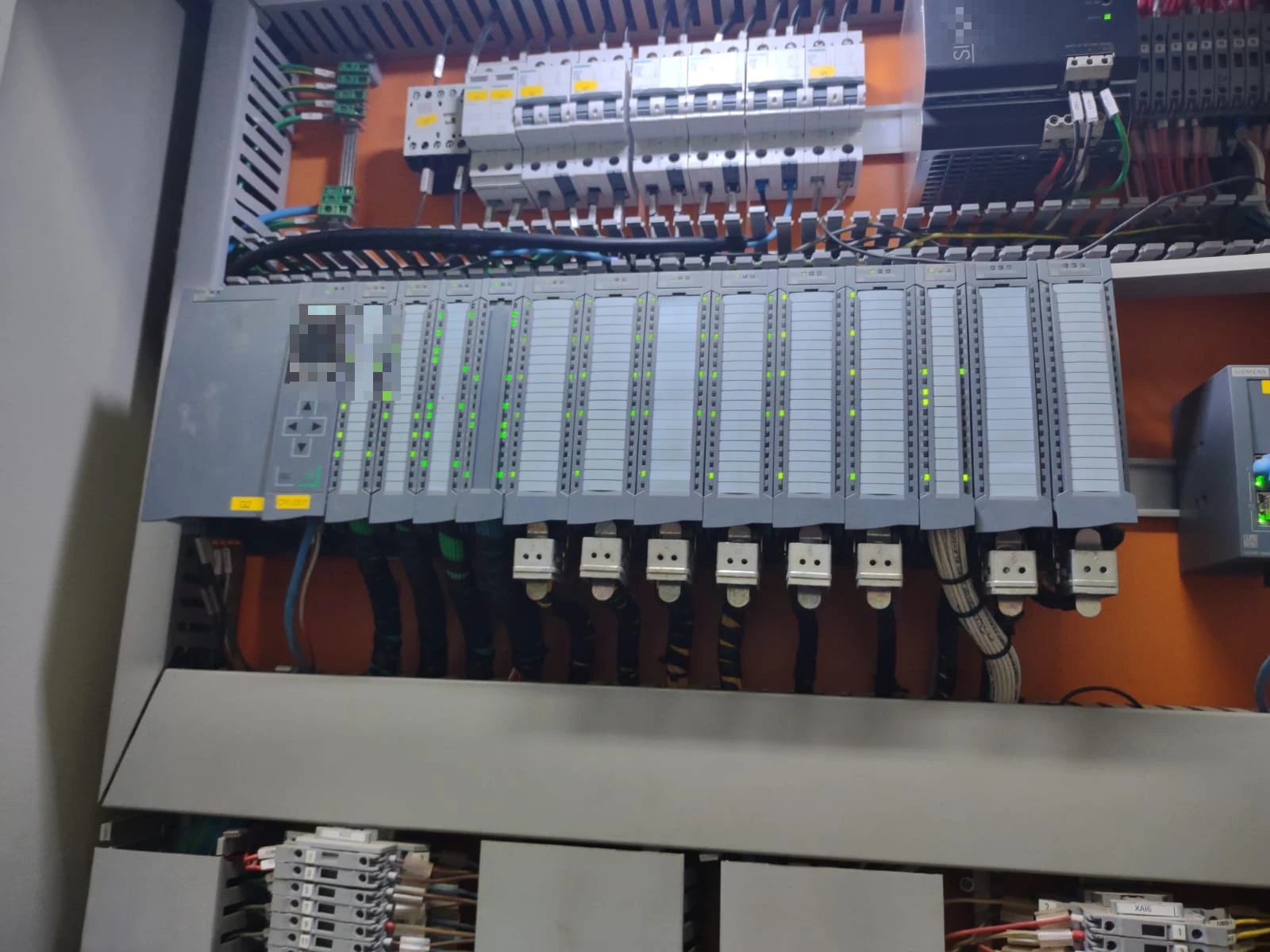 Rack de CLP em operação, com indicadores luminosos acesos, em painel industrial.